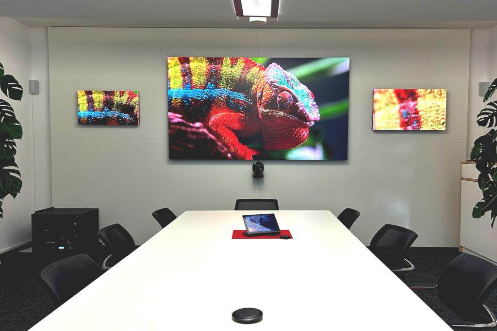 Konferenzraum mit Display, Videokonferenztechnik und professioneller Audiolösung